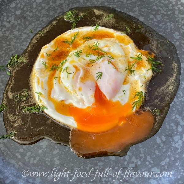 Poached eggs on garlic yogurt with spicy oil.